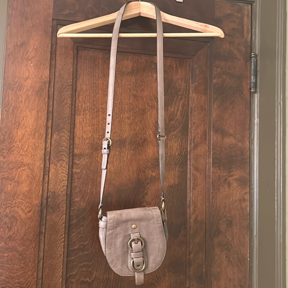 Adorable vintage mini COACH cross bracelet over bag.